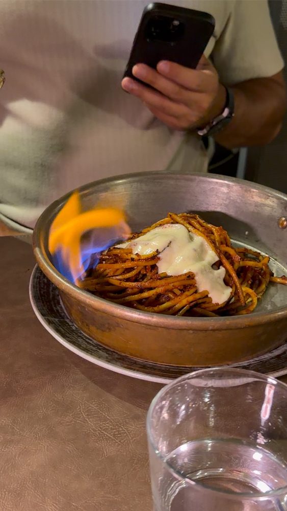 Spaghetti all'assassina set alight in a copper pan at the table