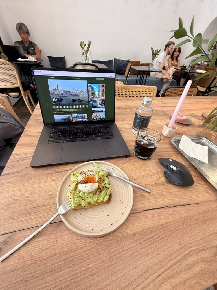 A laptop and avocado toast on a cafe table in Bari