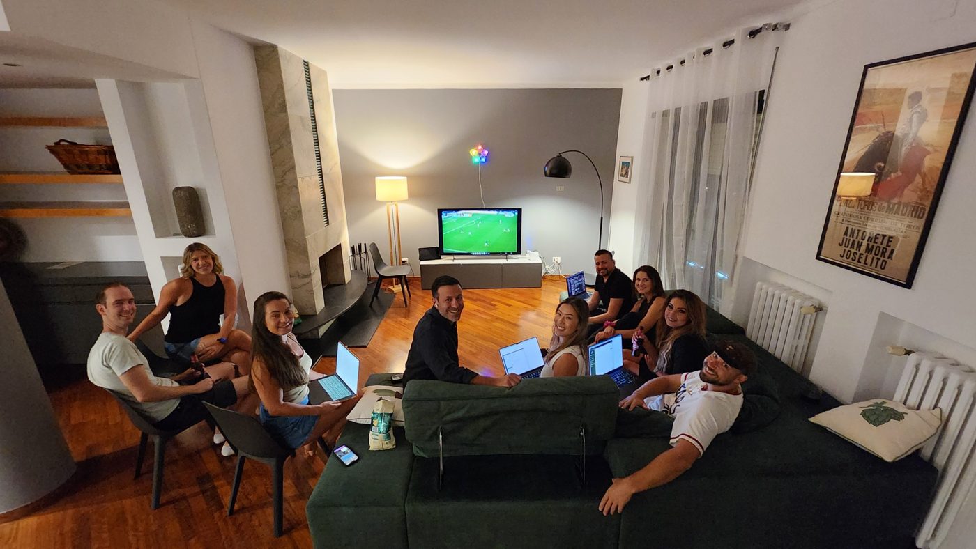 Members working on laptops together on a couch, the football on