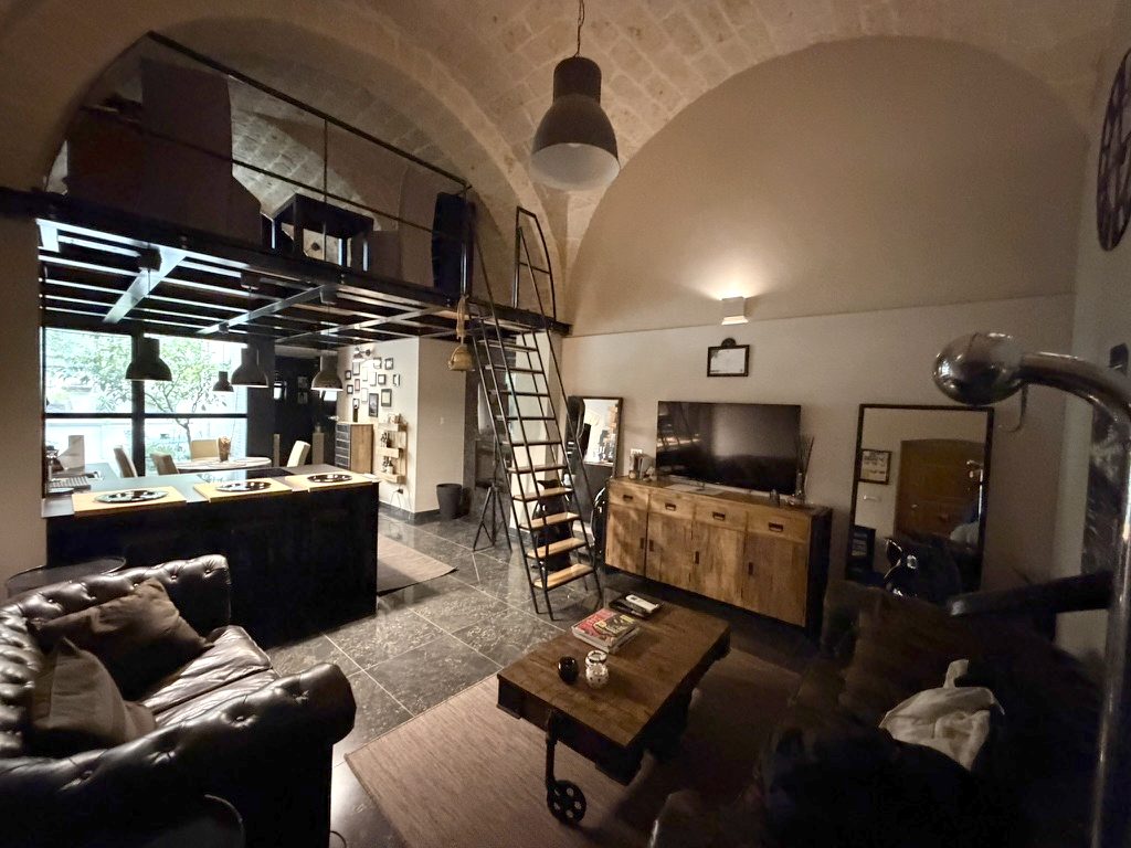 A member's apartment in Bari: stone vaults, a mezzanine, a leather sofa