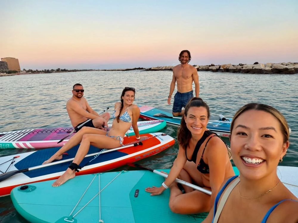 Members on paddleboards at sunset off Bari