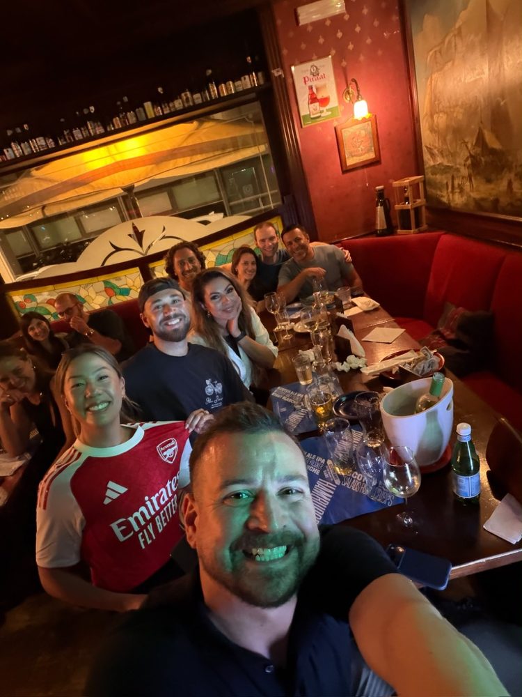 The crew in a red booth at a pub in Bari, the match on