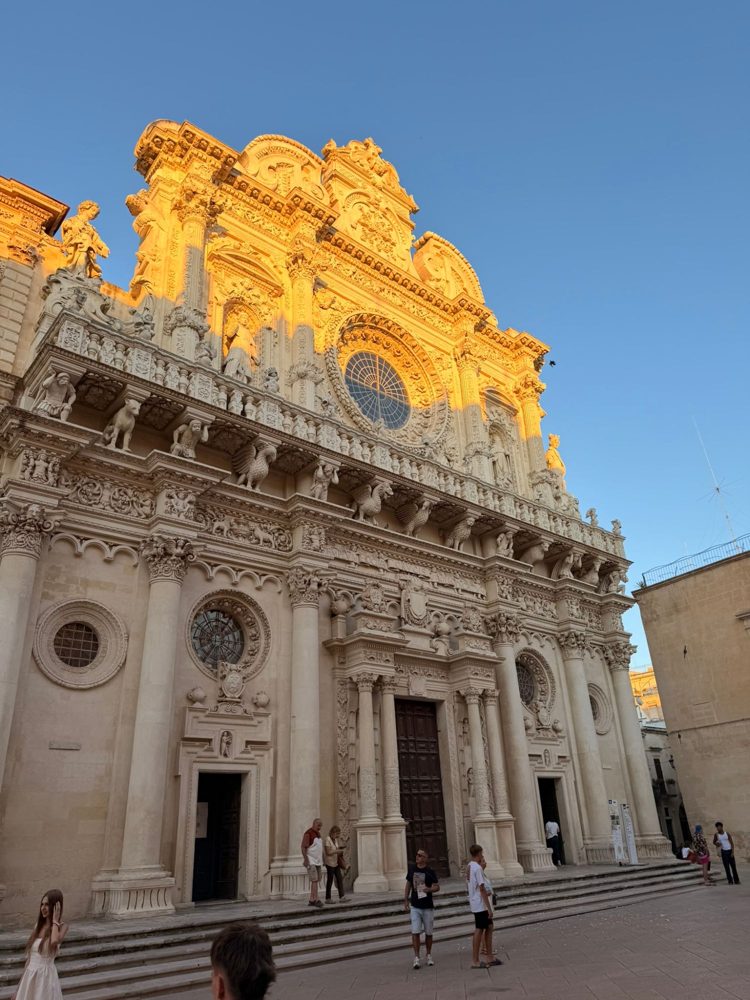 The baroque facade of Santa Croce in Lecce lit gold at sunset