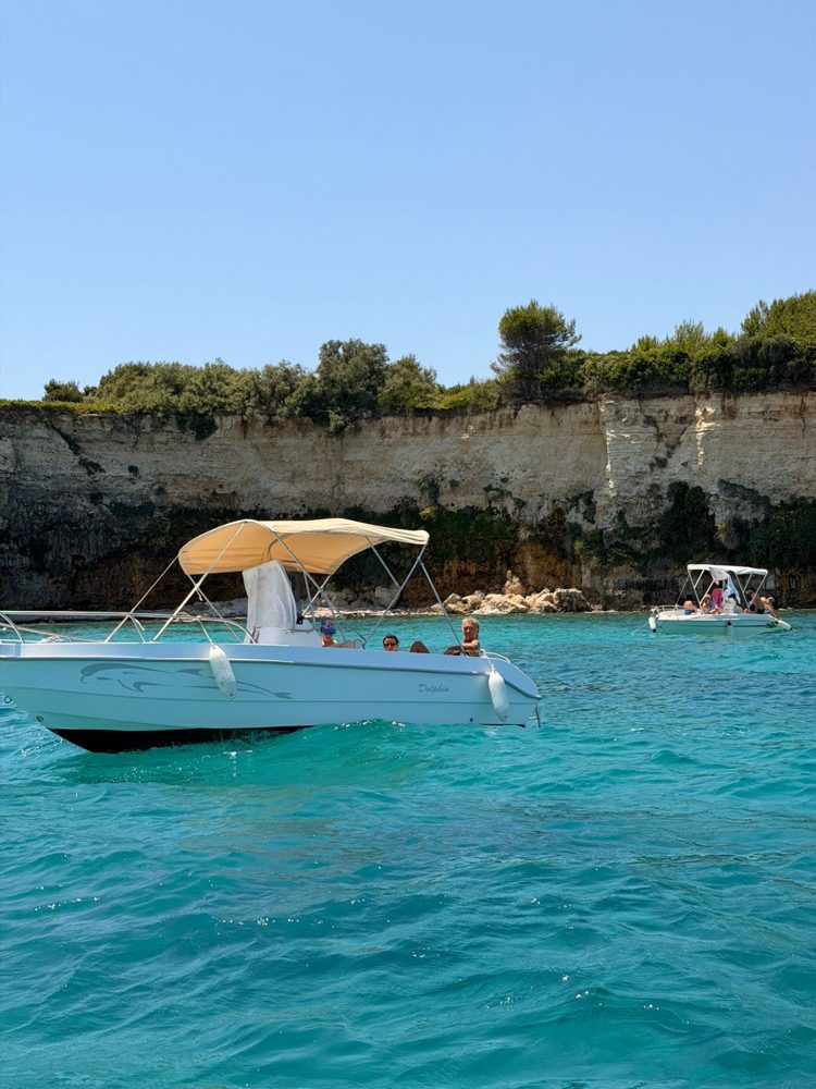 A rented boat under white cliffs on the Salento coast