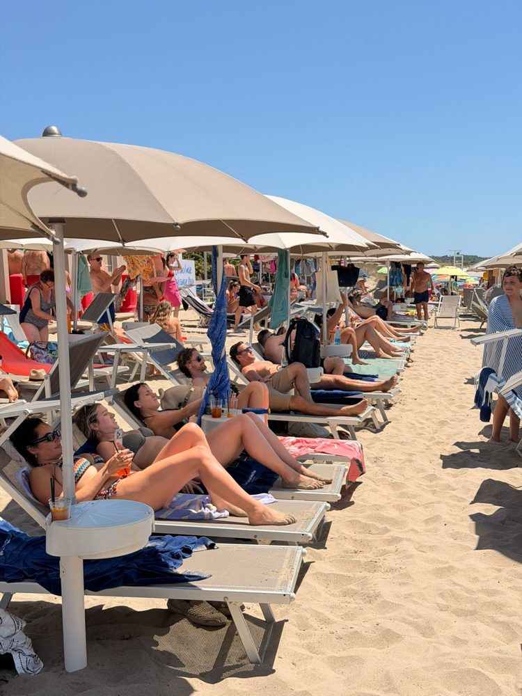 Members on loungers under umbrellas at the beach
