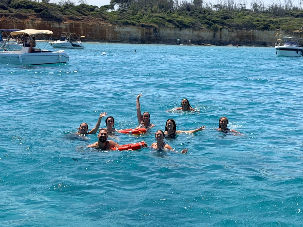 Members swimming off the boat in turquoise water